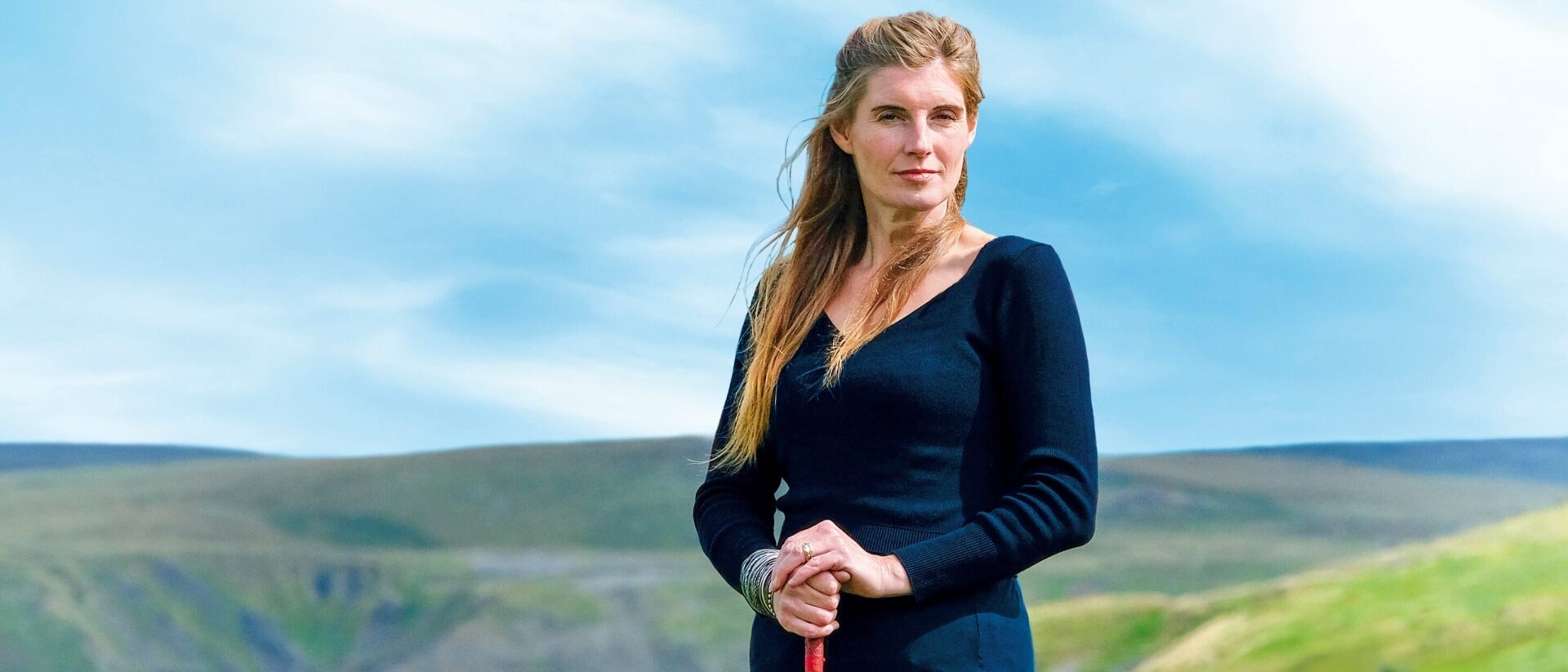 Amanda Owen standing on a hill.