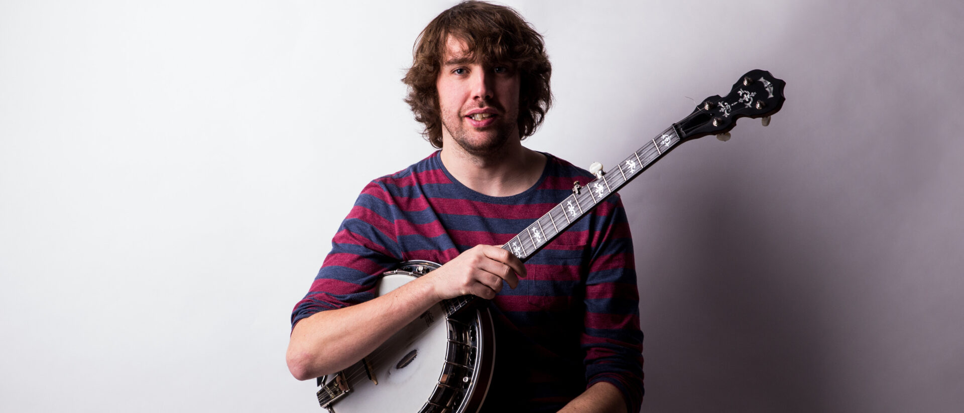 Professional headshot of Dan Walsh holding banjo