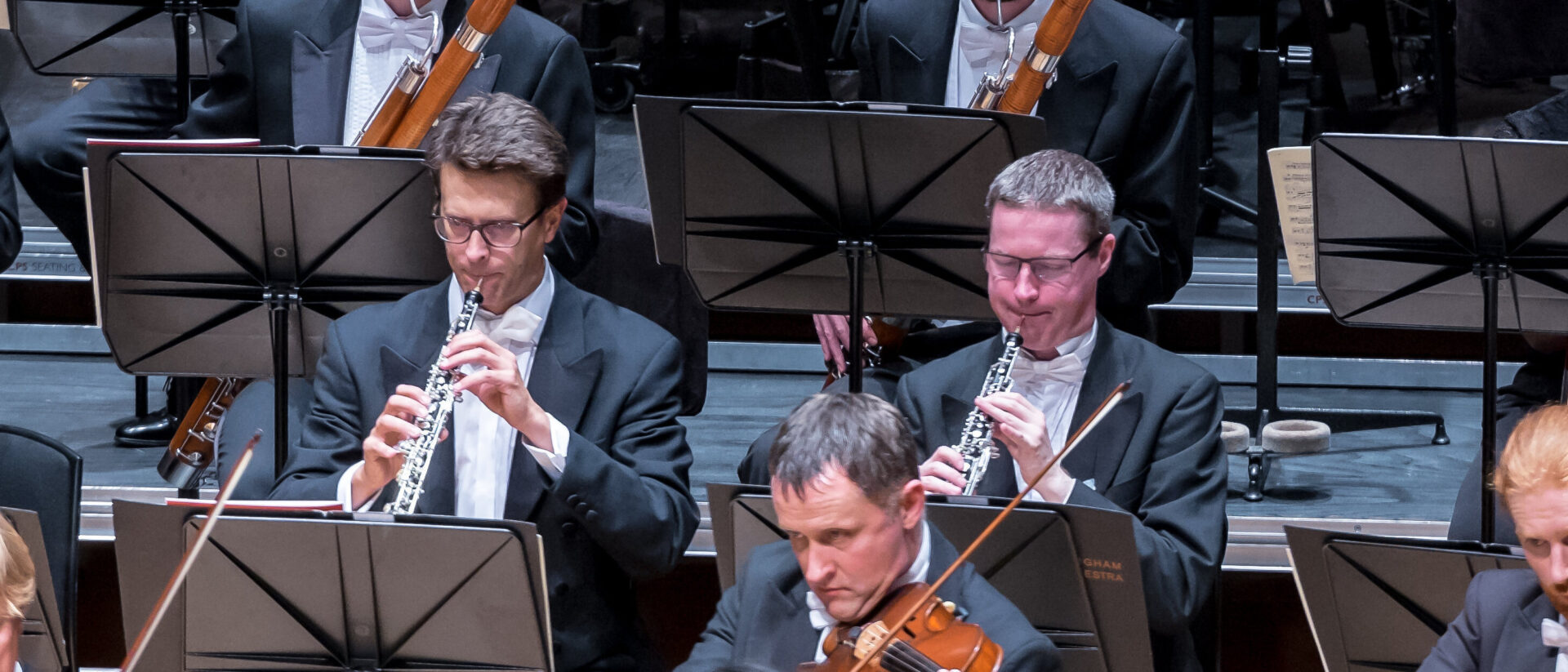 Close up of orchestra members playing on stage