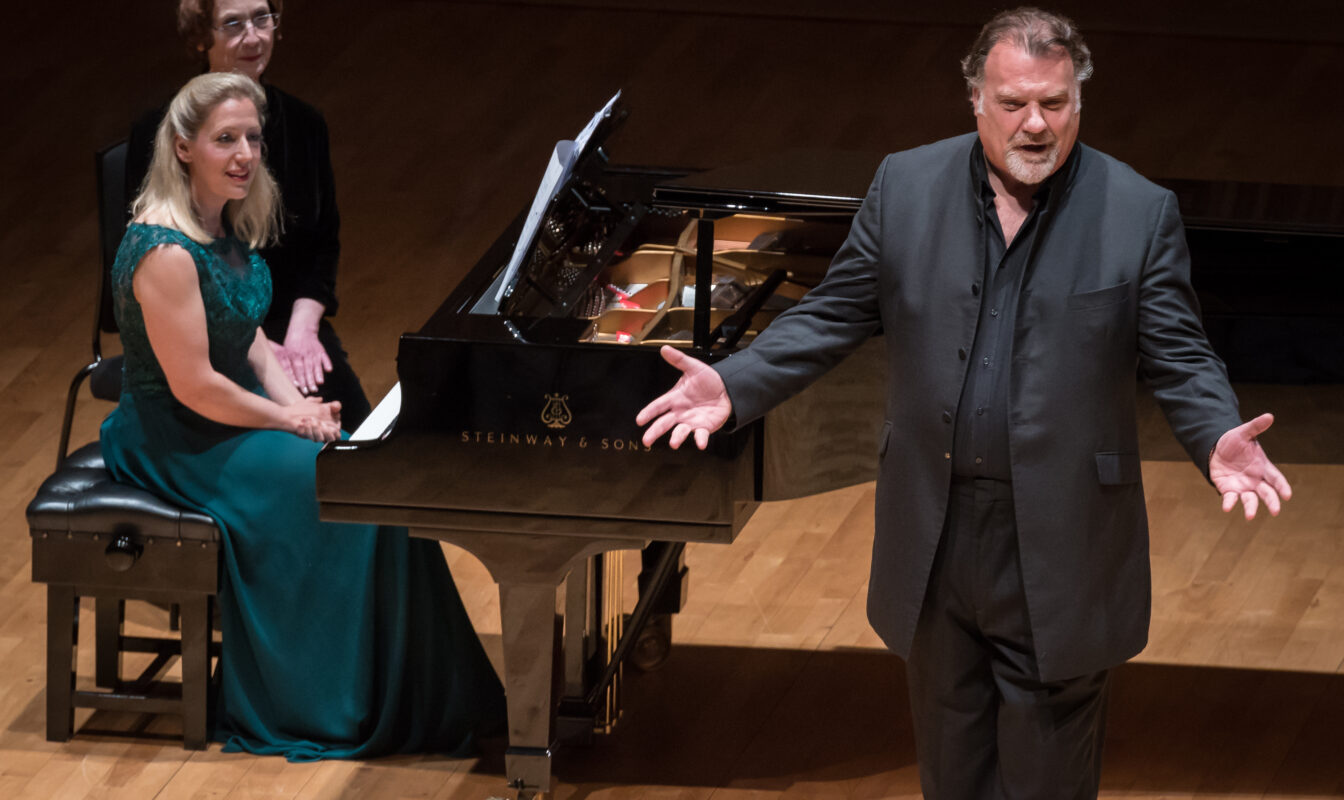 Singer Bryn Terfel gestures playfully at the audience mid-song